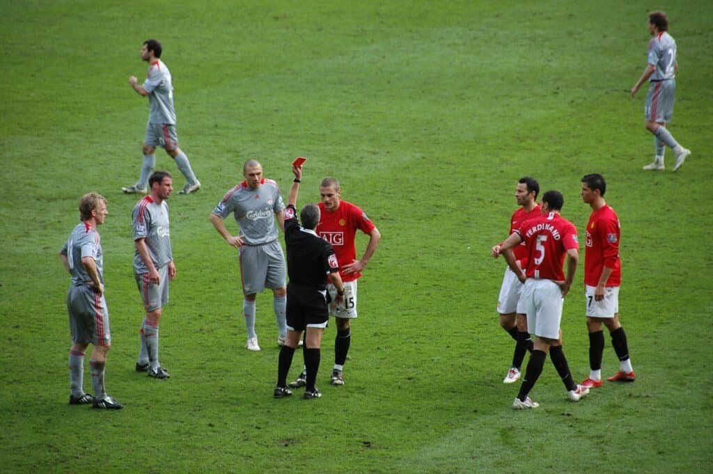 Árbitro de futebol aplica cartão vermelho a um jogador durante partida. Foto: Sdo216 (CC BY-SA 3.0)