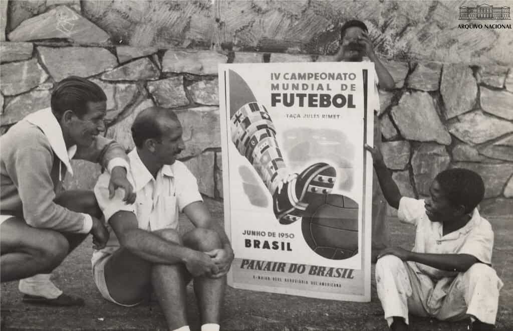 Torcedores observam cartaz da Copa do Mundo de 1950 no Brasil, época dos maiores públicos já registrados em um estádio (autor desconhecido, domínio público, Wikimedia Commons)